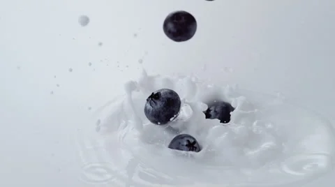 Blueberries falling into milk. Slow Motion. Stock Footage 60965240