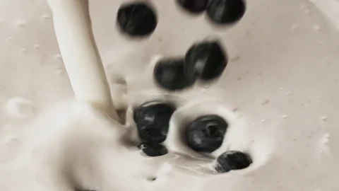 Blueberries falling to pouring yogurt full hd slow motion close up video Stock Footage 83937342