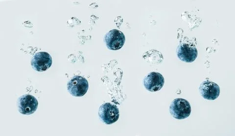 Blueberries falling into water. Stock Photos