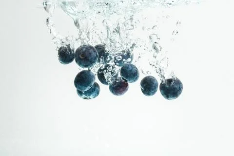 Blueberries falling into water. Stock Photos