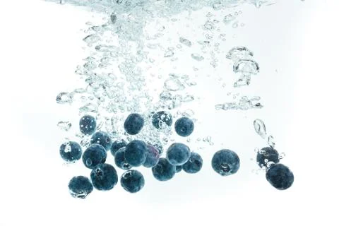 Blueberries falling into water. Stock Photos