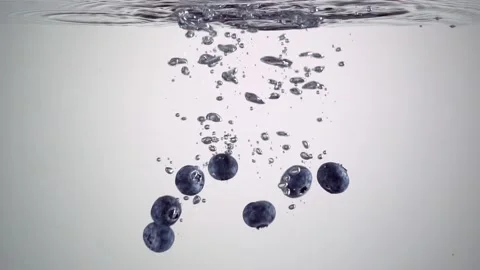 Blueberries falling in the water on white background Stock Footage 130965675