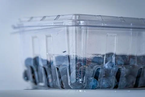 Blueberries packed in plastic container isolated on white background Stock Photos