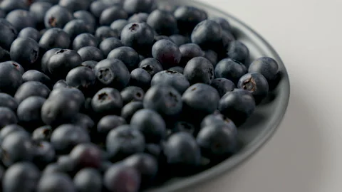 Blueberries rotating loop fresh produce fruit blue side angle on plate Stock Footage 138785307