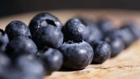 Blueberries in a Row on Wooden Table Camera Rotates Extreme Closeup Stock Footage 99137969