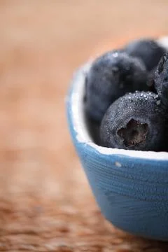Blueberries in a small blue dish on rustic background Stock Photos