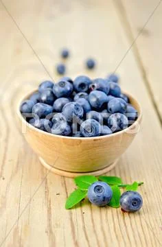 Blueberries in a wooden bowl on the board Stock Photos