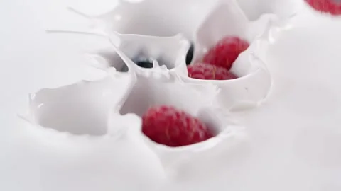 Blueberry and raspberry falling into thick white cream Stock Footage 171887550