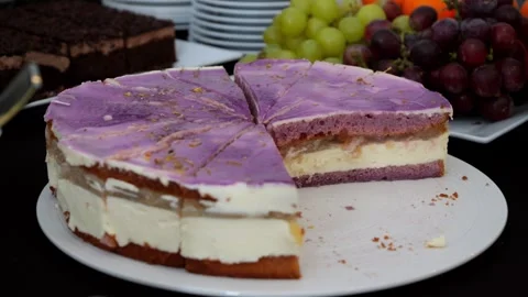 Blueberry cake, three-layered, cut into triangular slices on a table with sweet 스톡 동영상 300410728