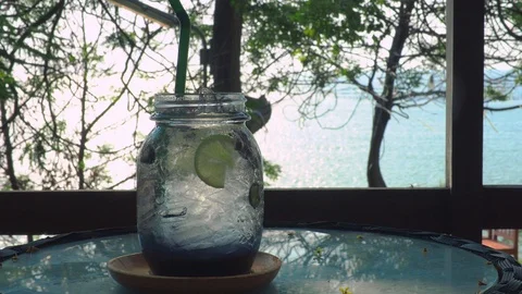 Blueberry fruit beverage on circle table under tree near beach in afternoon. Stock Footage 108831182
