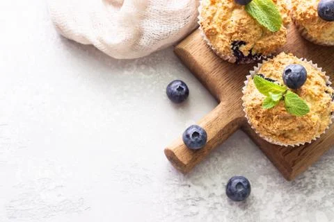 Blueberry muffins with berries and mint on a wooden board. Stock Photos