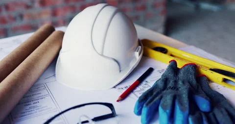 Blueprint, architecture and helmet on construction site for planning, PPE or Stock Footage 336803313