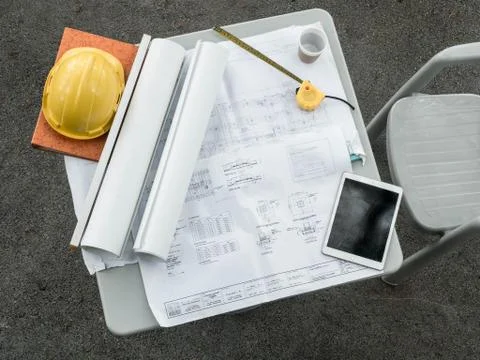 The blueprint is placed on the desk waiting for work and the engineering cap Stock Photos