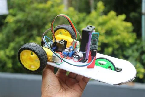 Bluetooth controlled robot car held in the hand on a natural background Stock Photos