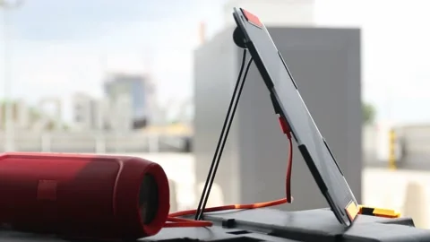 Bluetooth speaker connected to portable solar panel. Stock Footage 157589778