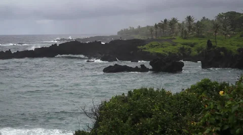 From a bluff people watch a storm roll in on the Maui coast Stock Footage 57670715
