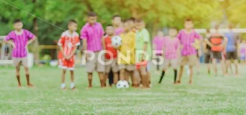 Blur of Asian boys practice kicking the ball to score goals in the public foo Stock Photos