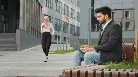 Blur background of muslim man in stylish wear. Pretty woman in hijab walking on Stock Footage 157276193