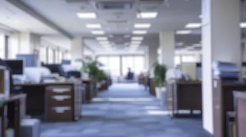 Blur background of office setup with rows of desks and natural lighting. Spate. Fotos Stock