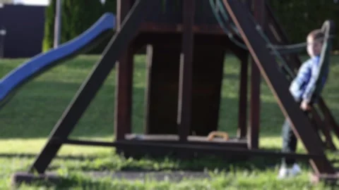 Blur, a child is swinging on a swing, a boy is riding on a swing in the yard Stock Footage 260485774