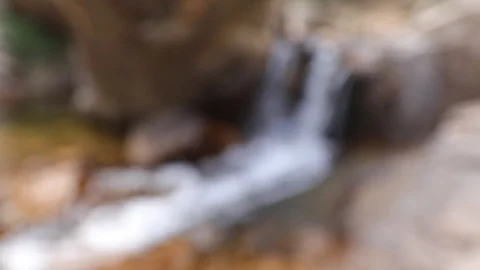 From blur to focused subject, stream flows on rocks Video stock 88971139