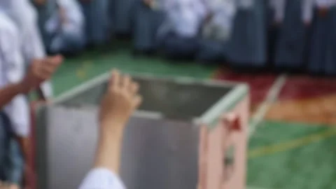 Blur of hands taking turns donating money into a charity box. Stock Footage 323240191