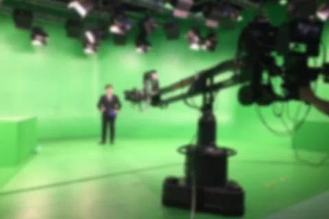 Blur image a television presenter in a TV camera in studio a green screen. Stock Photos
