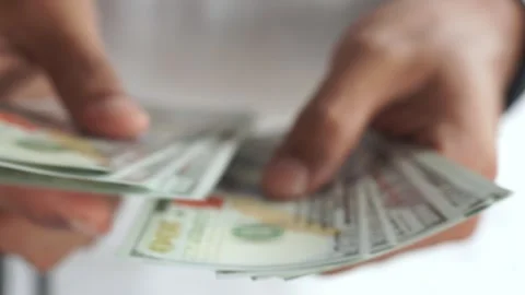 Blur. Man counting out dollar bills for an investment. Currency. Stock Footage 327649270