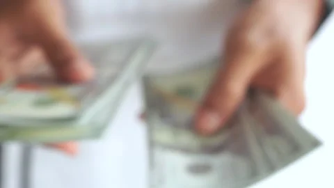 Blur. Man counting out dollar bills for an investment. Currency. Stock Footage 327649376