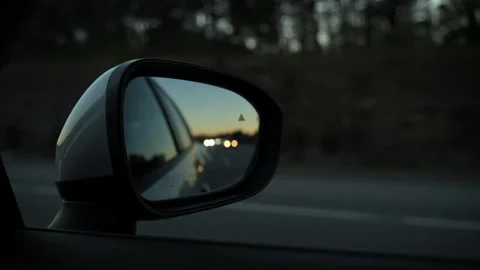 Blur reflection in the side mirror of driving car on the road on eveni Stock Footage 327565878