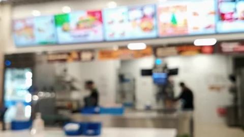 In blur, a trade workers at a fast food making a food at kitchen behind the cash Stock Footage 237423862