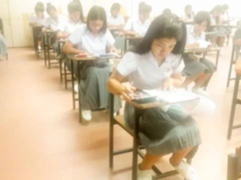 Blur  university students writing answer doing exam in classroom Stock Photos