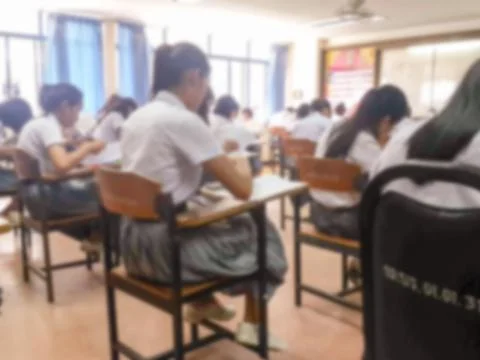 Blur  university students writing answer doing exam in classroom Stock Photos
