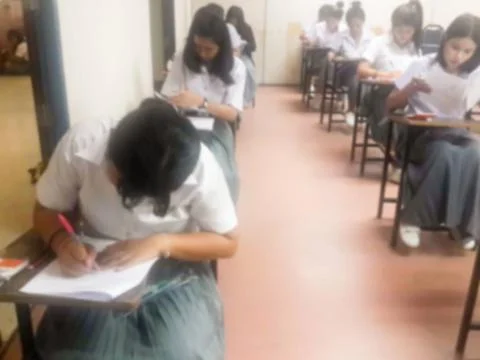 Blur  university students writing answer doing exam in classroom Stock Photos
