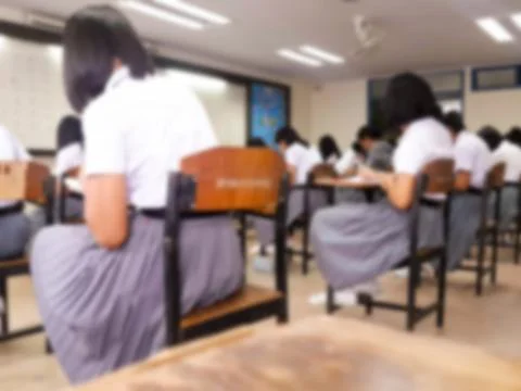 Blur  university students writing answer doing exam in classroom Stock Photos
