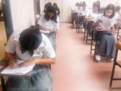 Blur  university students writing answer doing exam in classroom Stock Photos