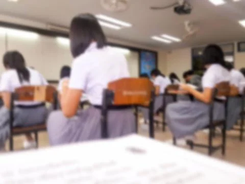Blur  university students writing answer doing exam in classroom Stock Photos