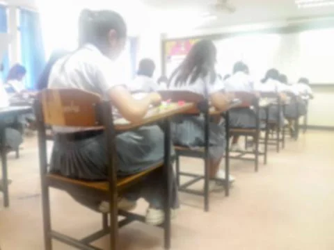Blur  university students writing answer doing exam in classroom Stock Photos
