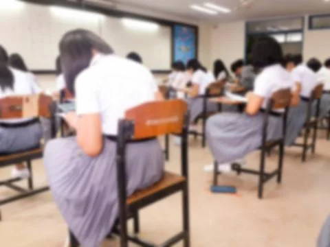Blur  university students writing answer doing exam in classroom Stock Photos