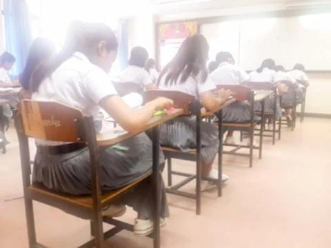 Blur  university students writing answer doing exam in classroom Stock Photos