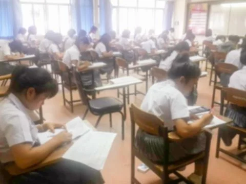Blur  university students writing answer doing exam in classroom Stock Photos
