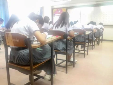 Blur  university students writing answer doing exam in classroom Stock Photos