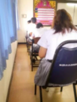 Blur  university students writing answer doing exam in classroom Stock Photos