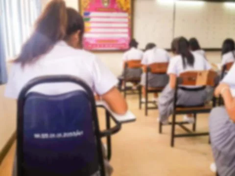 Blur  university students writing answer doing exam in classroom Stock Photos