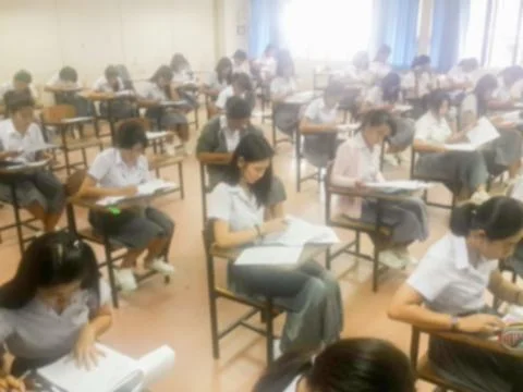 Blur  university students writing answer doing exam in classroom Stock Photos