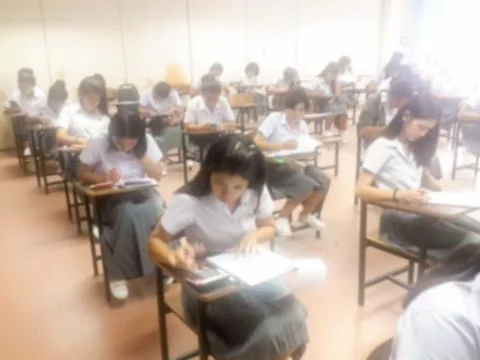 Blur  university students writing answer doing exam in classroom Stock Photos