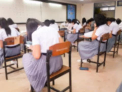 Blur  university students writing answer doing exam in classroom Stock Photos