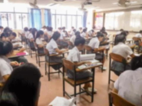 Blur  university students writing answer doing exam in classroom Stock Photos