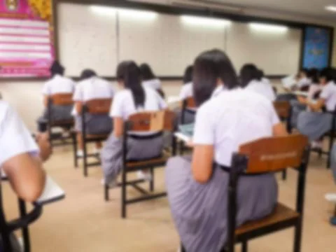 Blur  university students writing answer doing exam in classroom Stock Photos