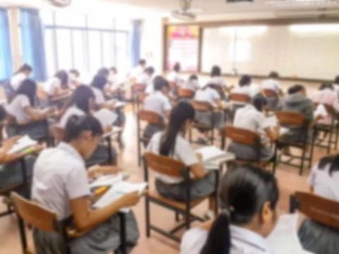 Blur  university students writing answer doing exam in classroom Stock Photos